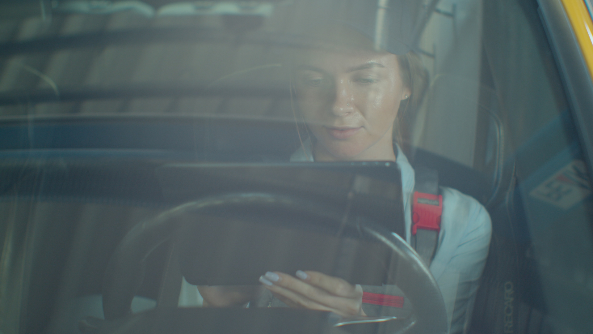 A truck driver checks her ELD while behind the wheel of her truck. 