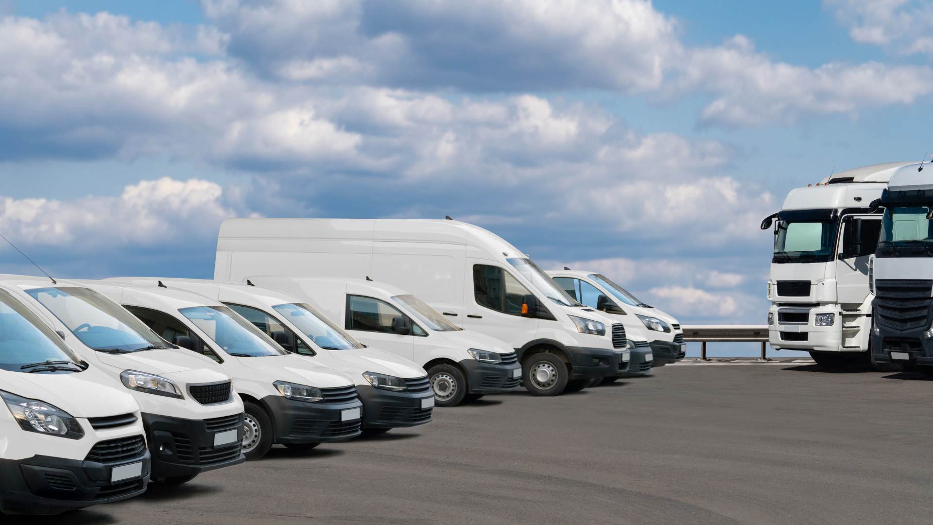 A fleet of different types of white fleet vehicles.