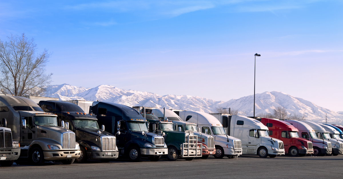 A line of refrigerated trailers with their semi-trucks at a truck stop in the US. 