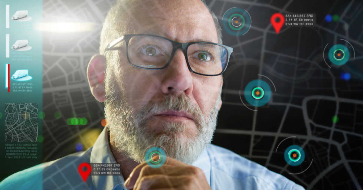 A man with gray hair and glasses with an overlay of Google mapping to represent fleet management with telematic software tools
