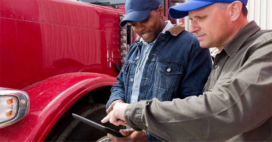 Two Men Truck Trailer Looking Tablet Fleet Management