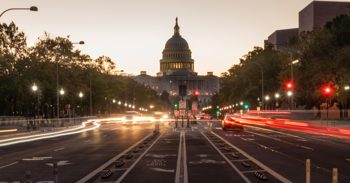 A street view of the US Capitol building at night with traffic moving. at night from 