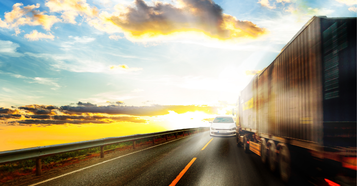 A white sedan swerving into the lane of an on-coming semi truck. 