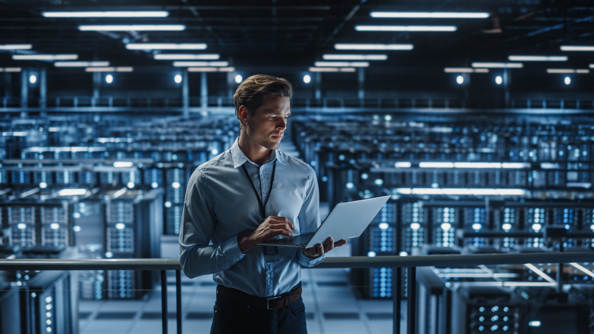 A federal employee oversees data in a warehouse full of servers. 